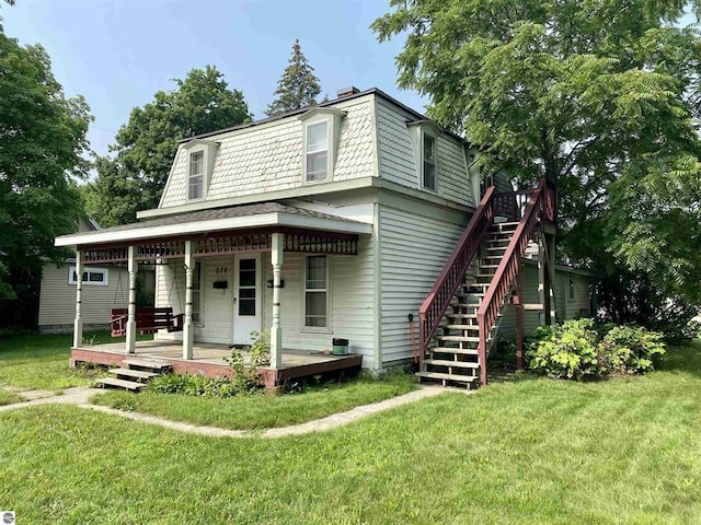 628 S Oak St, Mount Pleasant, MI 48858 - victorian home with mansard roof, a front yard, a porch, a chimney, and stairs