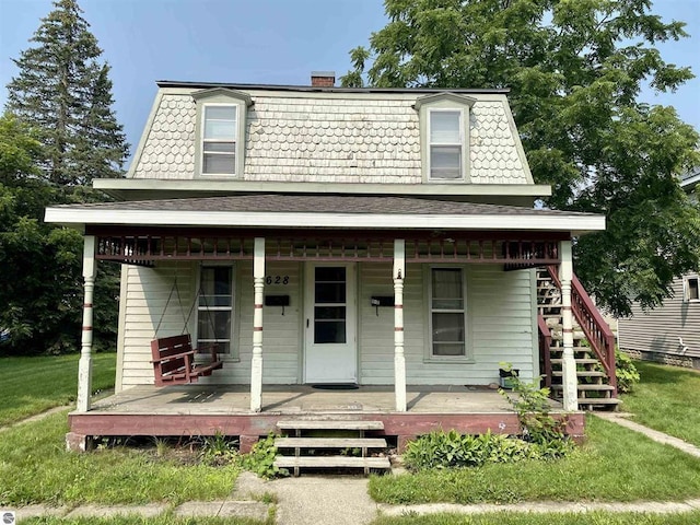 628 S Oak St, Mount Pleasant, MI 48858 - victorian home featuring mansard roof, a porch, a front yard, and a chimney