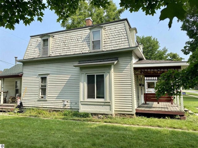 628 S Oak St, Mount Pleasant, MI 48858 - back of house featuring a chimney, a yard, a deck, and mansard roof