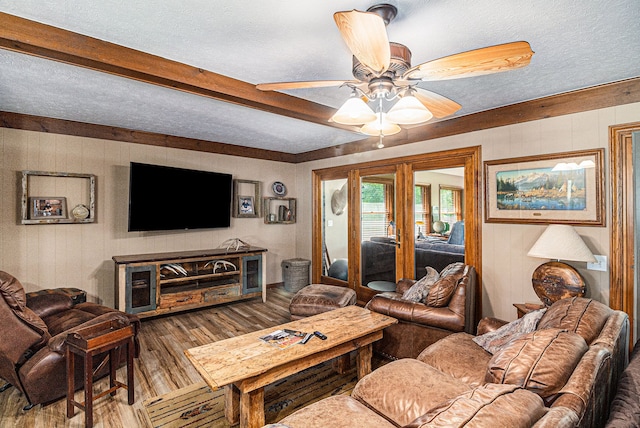 living room with hardwood / wood-style floors, ceiling fan, and a textured ceiling