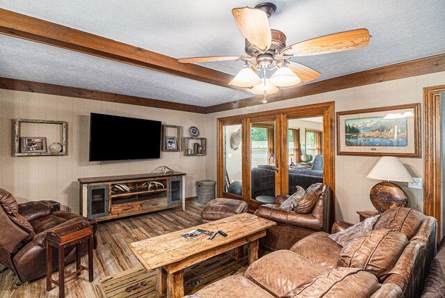 10133 W Allen Rd, Fowlerville, MI 48836 - living room featuring wood finished floors, a ceiling fan, a textured ceiling, beam ceiling, and wooden walls