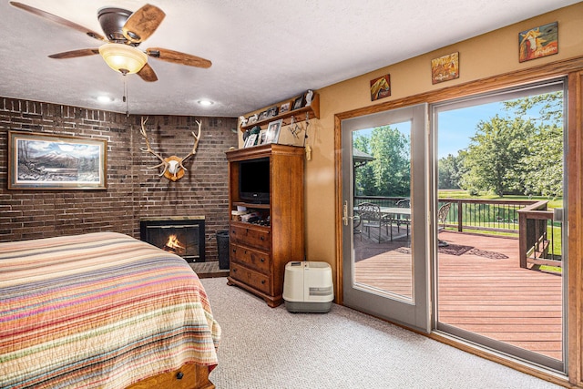 bedroom with access to outside, ceiling fan, light carpet, and a textured ceiling