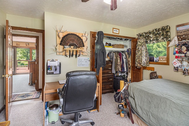 bedroom featuring carpet, a textured ceiling, a closet, and ceiling fan