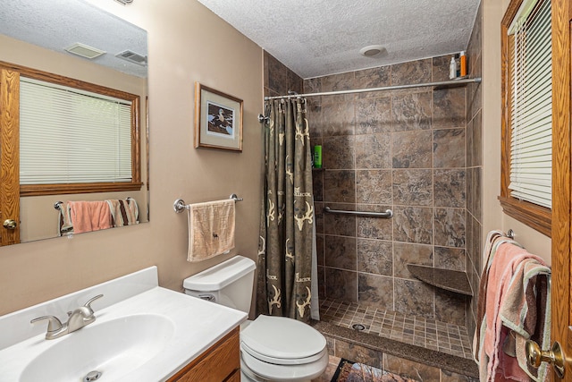 bathroom featuring vanity, a textured ceiling, toilet, and curtained shower