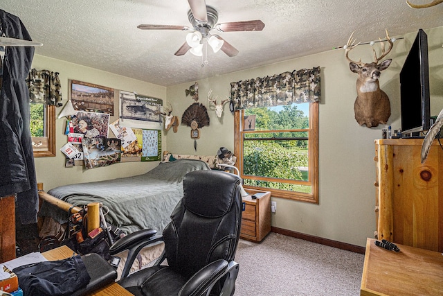 carpeted bedroom featuring ceiling fan and a textured ceiling