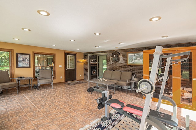 exercise area featuring tile patterned floors and brick wall