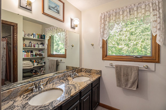 bathroom featuring a textured ceiling, vanity, and a wealth of natural light