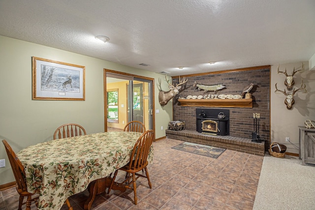 dining area featuring a wood stove and a textured ceiling