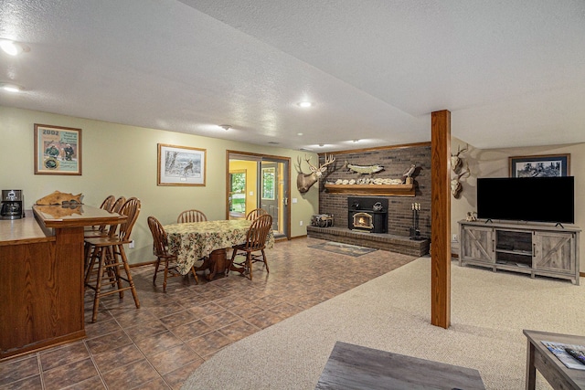 dining area with a wood stove and a textured ceiling