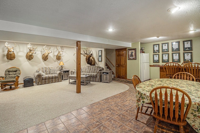 carpeted dining space featuring a textured ceiling