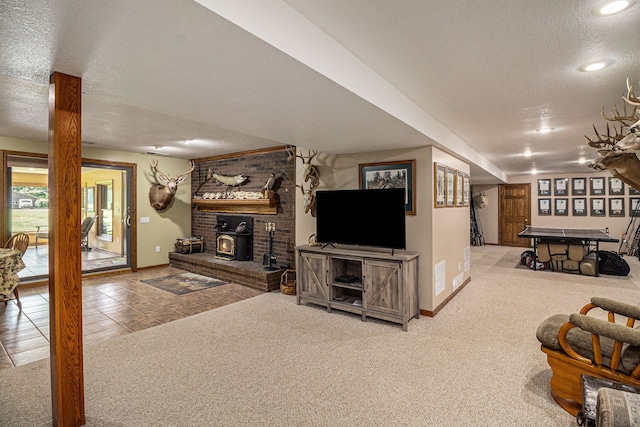 carpeted living room featuring a wood stove and a textured ceiling