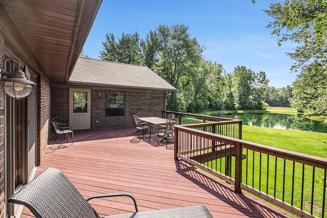 wooden deck featuring a water view and a yard