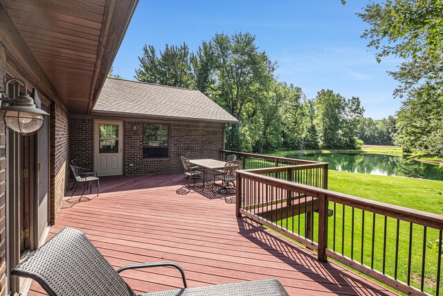 10133 W Allen Rd, Fowlerville, MI 48836 - deck featuring a water view, outdoor dining area, and a yard