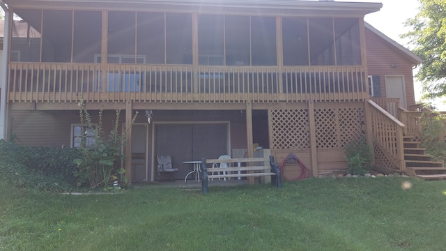 rear view of property featuring a sunroom, a deck, and a yard