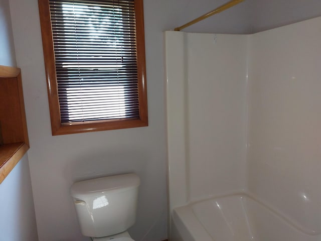 bathroom featuring bathing tub / shower combination and toilet