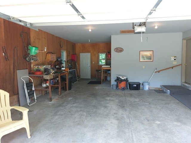 garage with wood walls and a garage door opener