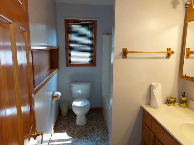 bathroom with a tub to relax in, vanity, and toilet