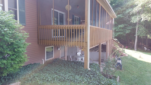 view of side of home with a lawn and a balcony