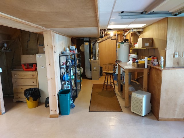 basement with heating unit, a workshop area, and gas water heater