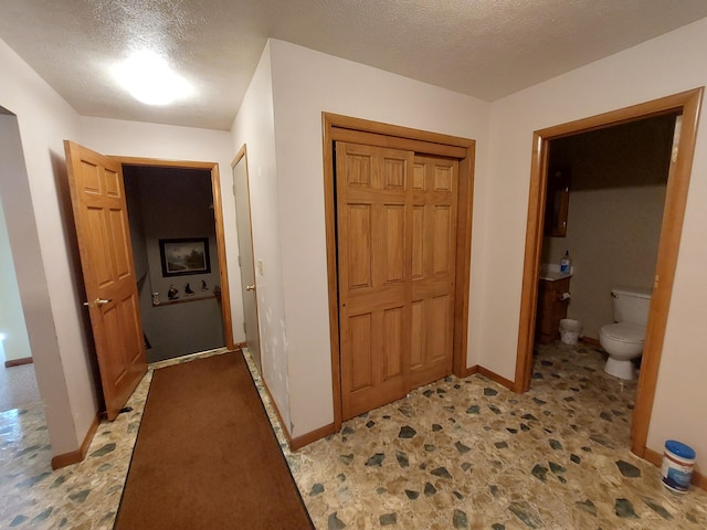 hall featuring a textured ceiling