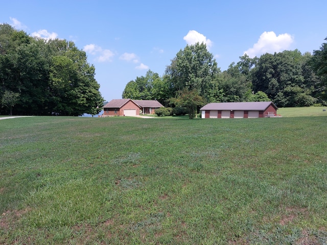 view of yard featuring a garage and an outbuilding