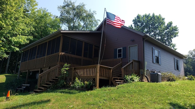 back of house featuring a yard, central AC unit, and a sunroom