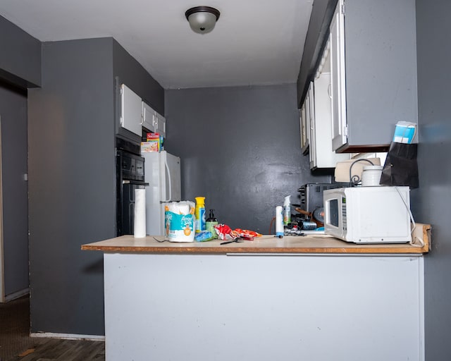 kitchen featuring white cabinets, white appliances, and dark wood-type flooring