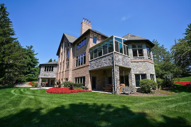 rear view of property featuring a sunroom and a yard