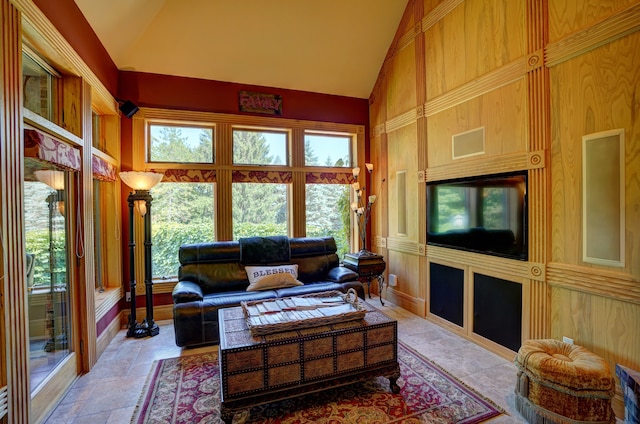 living room with high vaulted ceiling and wooden walls