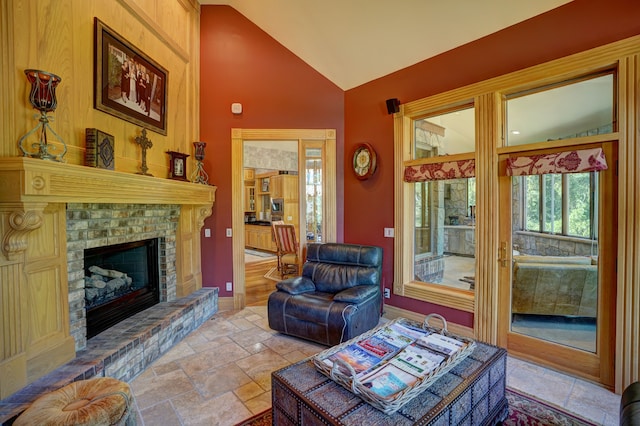 living room featuring vaulted ceiling and a brick fireplace