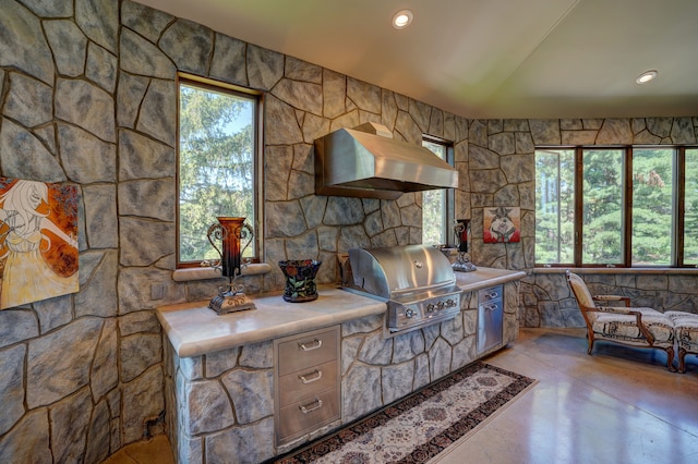 kitchen featuring wall chimney range hood