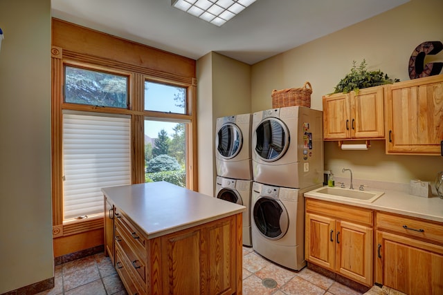 clothes washing area with stacked washer and dryer, cabinets, and sink