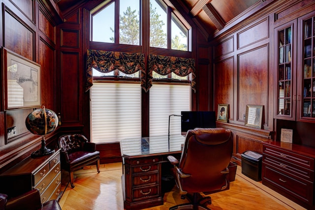 office space featuring vaulted ceiling with beams, wooden walls, light hardwood / wood-style floors, and coffered ceiling