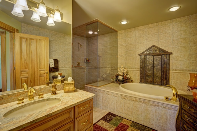 bathroom with tile patterned floors, vanity, tile walls, and independent shower and bath