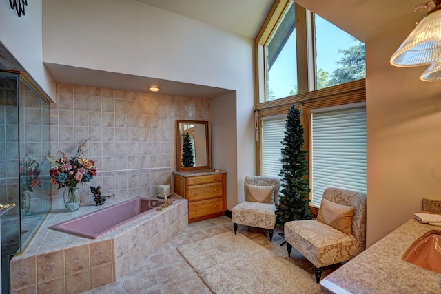 sitting room featuring light tile patterned floors, tile walls, and a high ceiling