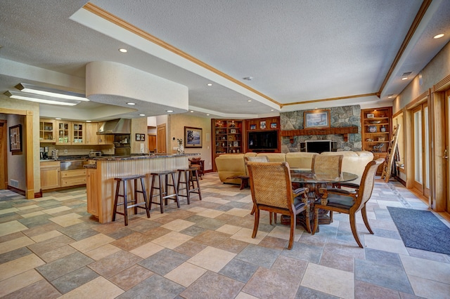 dining area with built in features, a textured ceiling, and a tray ceiling