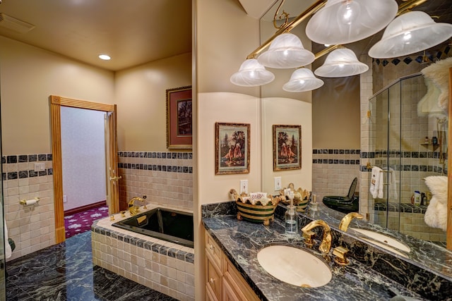 bathroom featuring vanity, shower with separate bathtub, and tile walls