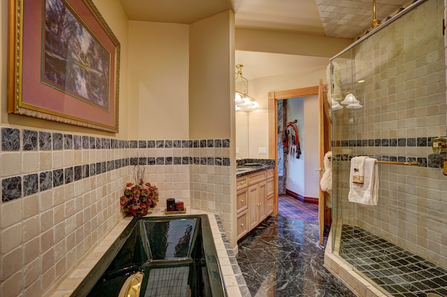 bathroom with vanity, a shower with door, and tile walls