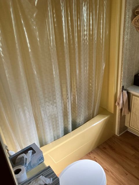 7377 Birch Dr, Port Hope, MI 48468 - full bathroom with shower / bathtub combination with curtain, wood finished floors, and toilet