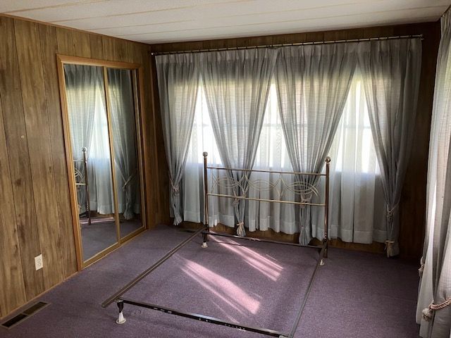 7377 Birch Dr, Port Hope, MI 48468 - carpeted empty room featuring wood walls