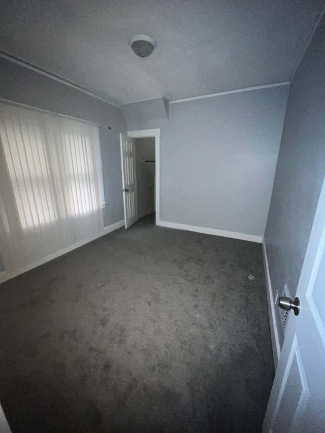unfurnished bedroom featuring a textured ceiling and dark colored carpet