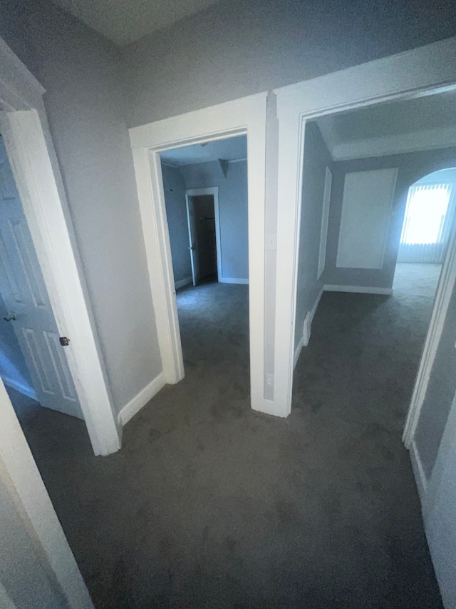 hall with dark colored carpet