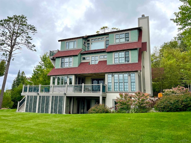 back of property featuring a wooden deck and a yard