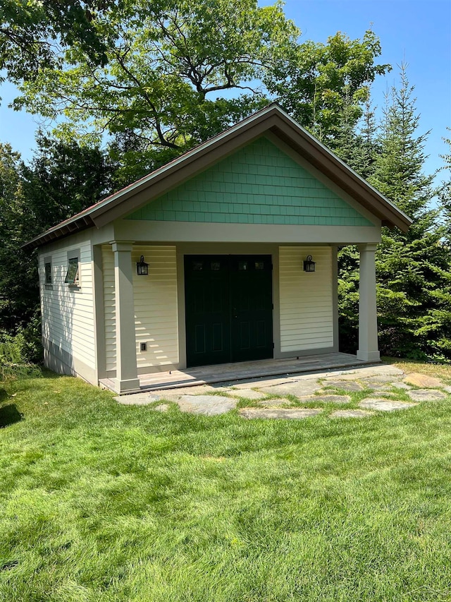 view of front of home featuring a front lawn and an outdoor structure