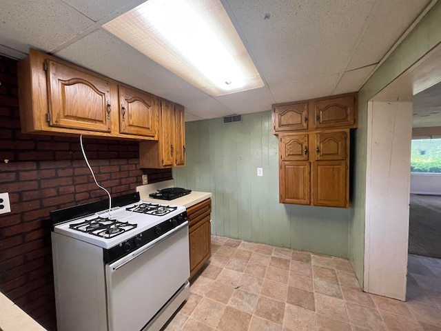 kitchen with a drop ceiling and gas range gas stove