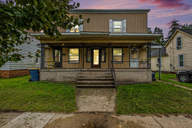 view of front of house featuring covered porch and a yard