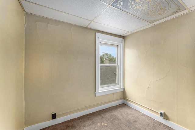 carpeted empty room with a drop ceiling