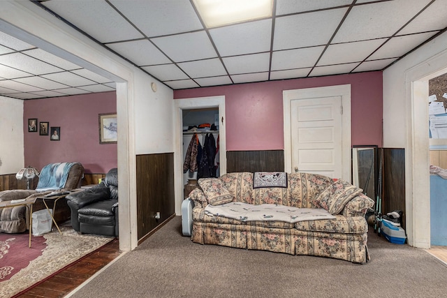 living room with carpet and a paneled ceiling