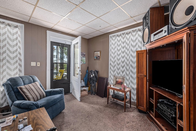 living room with a paneled ceiling and carpet