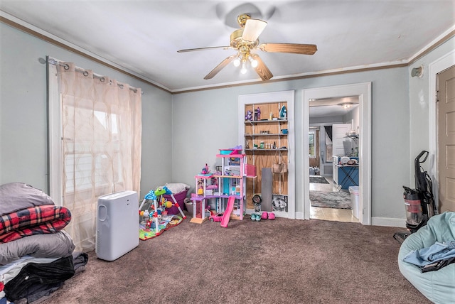 playroom featuring carpet flooring, crown molding, and ceiling fan